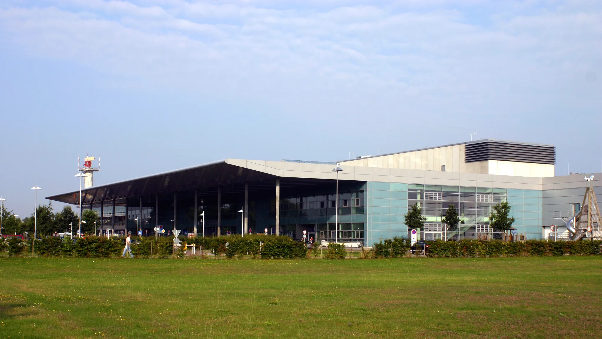 The glass terminal building at Münster/Osnabrück Airport across its lawn