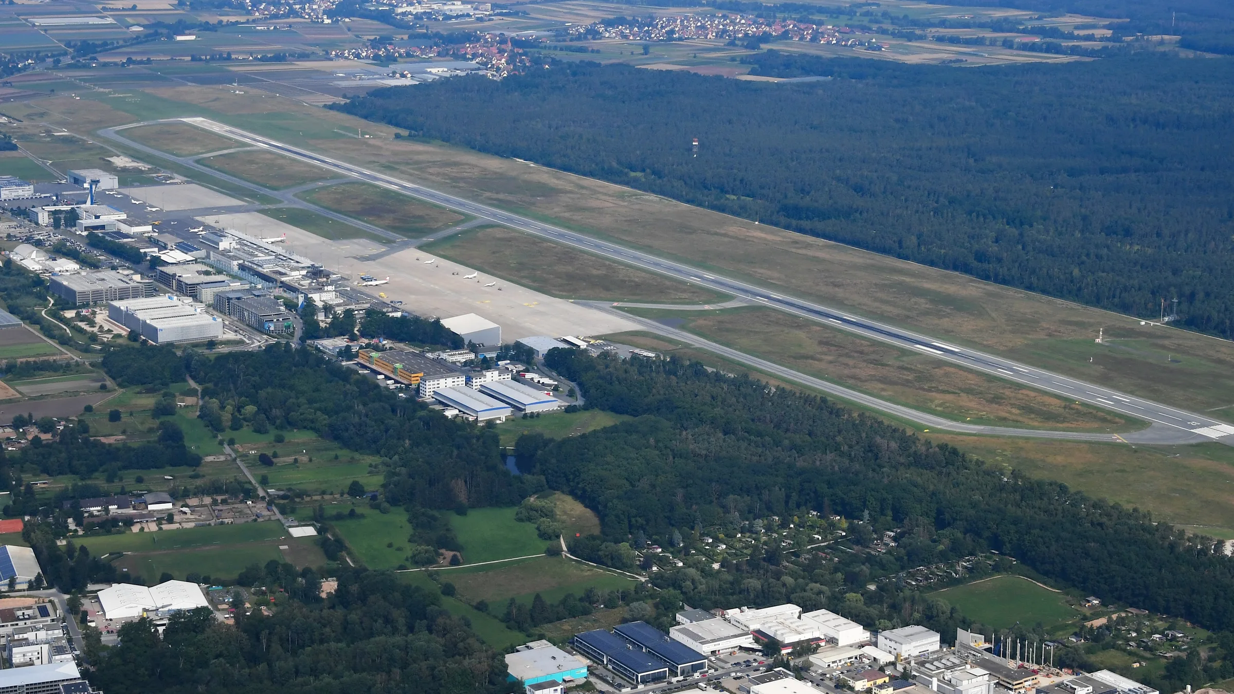 Nuremberg Airport from the air, its single runway cut through the Reichswald forest