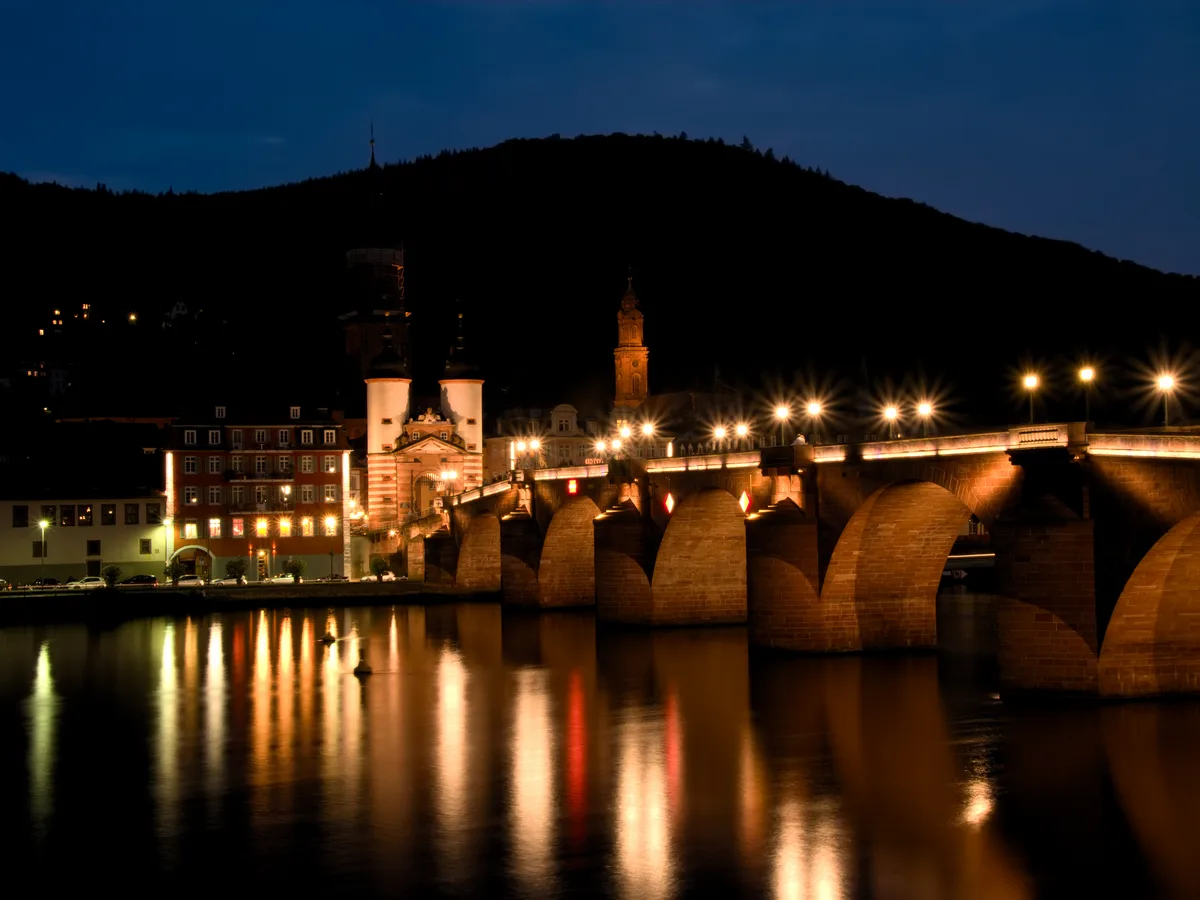 The Alte Brücke and the old town of Heidelberg floodlit above the Neckar at night