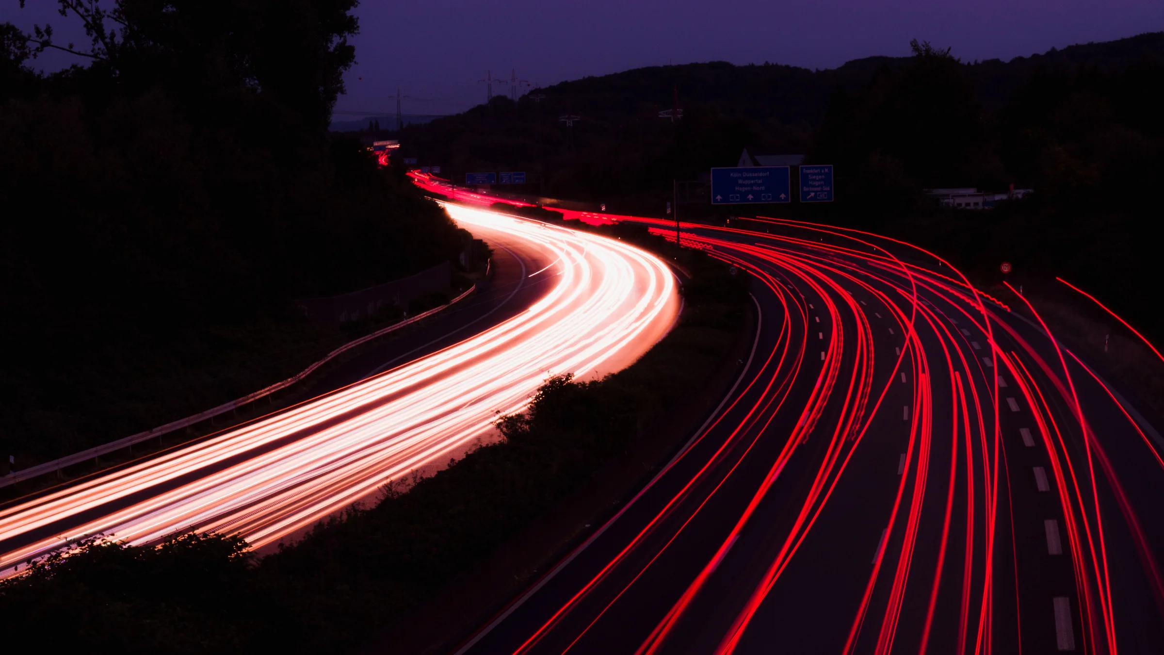 Tail lights streaking along a German autobahn at night — GermanRide chauffeur service